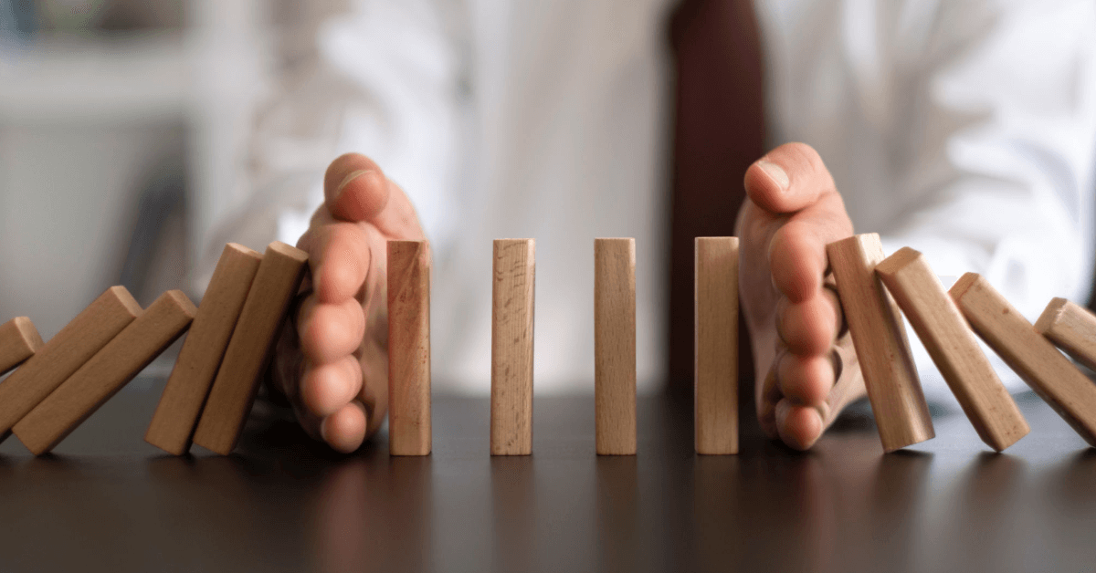 a man keeping dominoes from falling