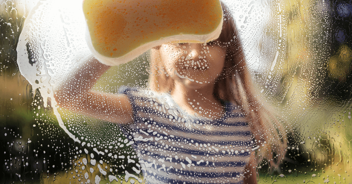 a young kid cleaning a window